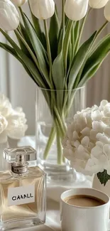 Elegant floral display with perfume and coffee on table.