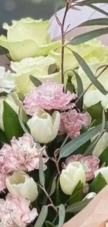 Elegant bouquet of pastel pink and white flowers with lush green leaves.