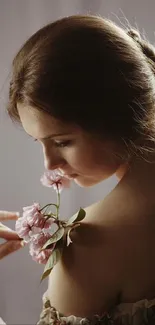 Elegant woman with pink flowers against soft brown background.