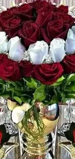 Elegant bouquet of red and white roses in a golden vase.