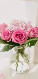 Pink rose bouquet in glass vase on a white chair.