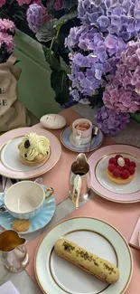 Elegant table with pastel hydrangeas and desserts.