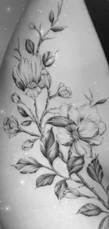 Black and white floral tattoo on arm with elegant details.