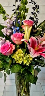 Elegant floral vase with vibrant roses and lilies against a subtle brick wall.