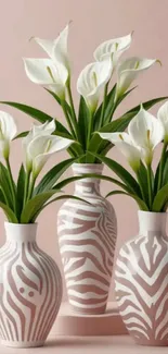 Elegant floral vases with calla lilies on a soft pink background.