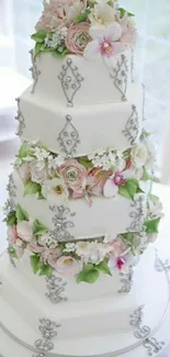 Five-tiered floral wedding cake with silver accents.