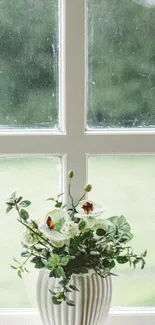 Floral arrangement in vase by window with garden view.