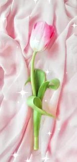 Single pink tulip on silky pink fabric with sparkles.