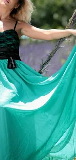 Woman in a teal dress standing outdoors.