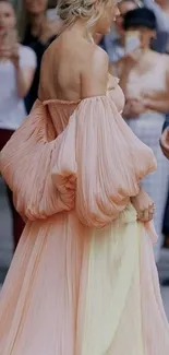 Elegant woman in a flowing peach dress.