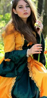 Elegant woman in orange dress with flower in forest setting.