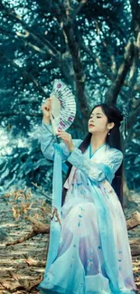 Woman in traditional dress with fan in forest.