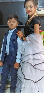 Siblings in elegant formal attire posing.