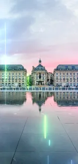 Place de la Bourse reflecting in water during a pink sunset.