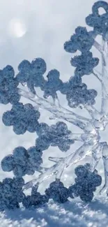 Close-up of a frosted snowflake pattern in light blue hues on a wintry background.