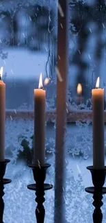 Three candles by frosted window creating a cozy winter ambiance.