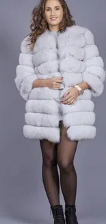 Woman in elegant fur coat against gray background.