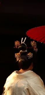 Geisha with a red umbrella in traditional attire.