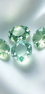 Four shimmering gemstones on soft fabric background.