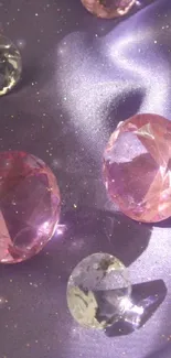 Glistening pink gemstones on purple silk background.