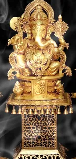 Gold Ganesha statue on ornate stand with dark background.