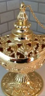 Gold lamp with intricate design on elegant wallpaper.