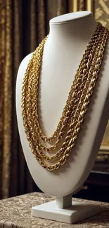 Luxurious display of gold chains on a mannequin bust in an elegant setting.