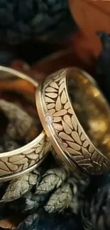 Close-up of elegant gold rings with intricate design on dark background.