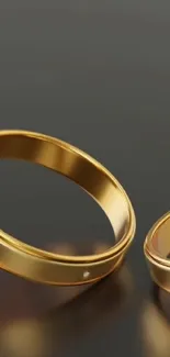 Elegant gold rings on a sleek black background, perfect for mobile wallpaper.