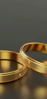 Two gold rings with elegant design, perfect for a mobile wallpaper.