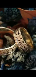 Gold wedding rings on floral background.