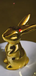 Golden bunny figurine next to a dotted egg on a stylish plate.