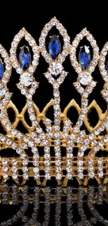 Luxurious golden crown with blue jewels on a black background.