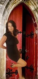 Woman posing by gothic red door archway, elegant and mysterious design.