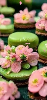 Green and pink desserts with floral decorations on a dark background.