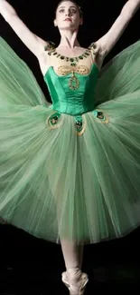 Ballet dancer in green tutu performing elegant pose against black background.