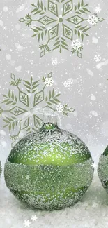 Elegant green Christmas ornaments with snowflakes on a festive wallpaper.