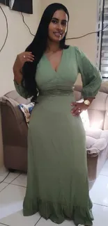 Woman in elegant green dress standing in stylish room.