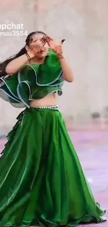 Woman in flowing green dress dancing gracefully in elegant attire.