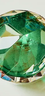 Emerald green faceted gemstone on beige background.