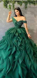 Woman in elegant emerald green gown standing.