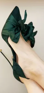 Elegant dark green satin high heels with bows for a chic wallpaper.