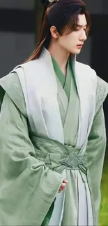 Serene figure in elegant green robe standing calmly.