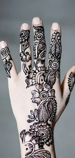 Elegant henna mehndi design on hand with intricate details on gray background.