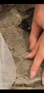 Hand with pink nails on stone surface, elegant wallpaper.