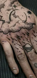 Hand tattoo featuring stars and clouds, artistic design.