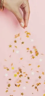 Hand with golden stars on pink background wallpaper.