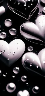 Silver heart shapes with water drops on black background.