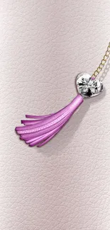 Heart necklace with pink tassel on a light background.