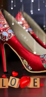 Stylish red heels with love-themed blocks on a wooden floor.